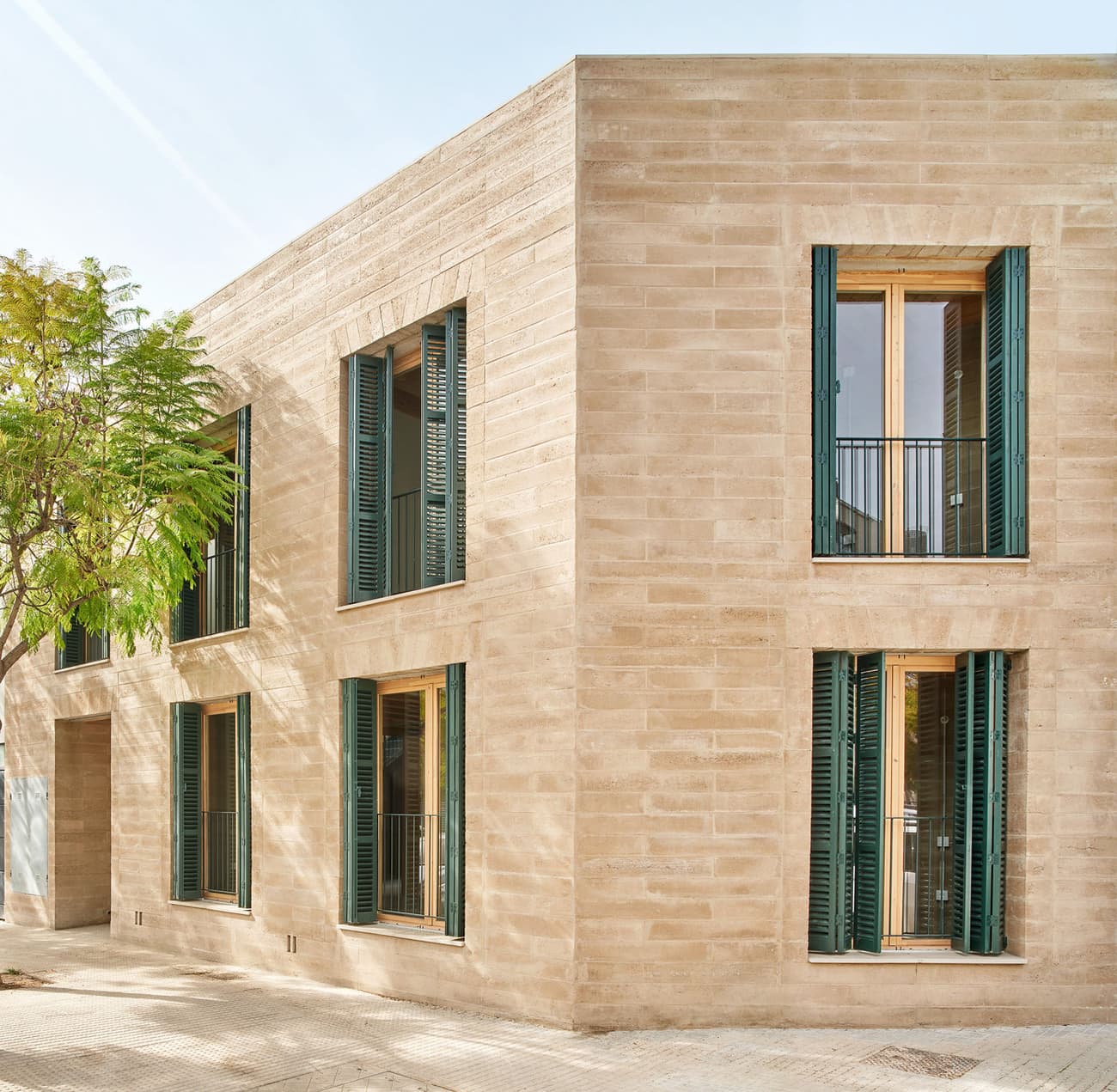 Architectural project - vertical windows, green shutters, stone facade, beige facade, natural stone, urban dwelling, minimal facade, wooden shutters, thermal efficiency, sunlight optimization, minimalist appeal, natural materials, eco-friendly design, wood, city living, outdoor space, warm tones, natural tones, contemporary architecture, green, daylight, urban environment, beige, exterior design, modern aesthetic, functional design, minimalist design, neutral colors, passive cooling, urban design, sustainable building, natural ventilation, modern facade, clean lines, large windows, architectural simplicity, energy efficient, stone, residential architecture, residential building, sleek design, timeless design, modern living, facade texture, urban context, geometric form, townhouse, stone texture
