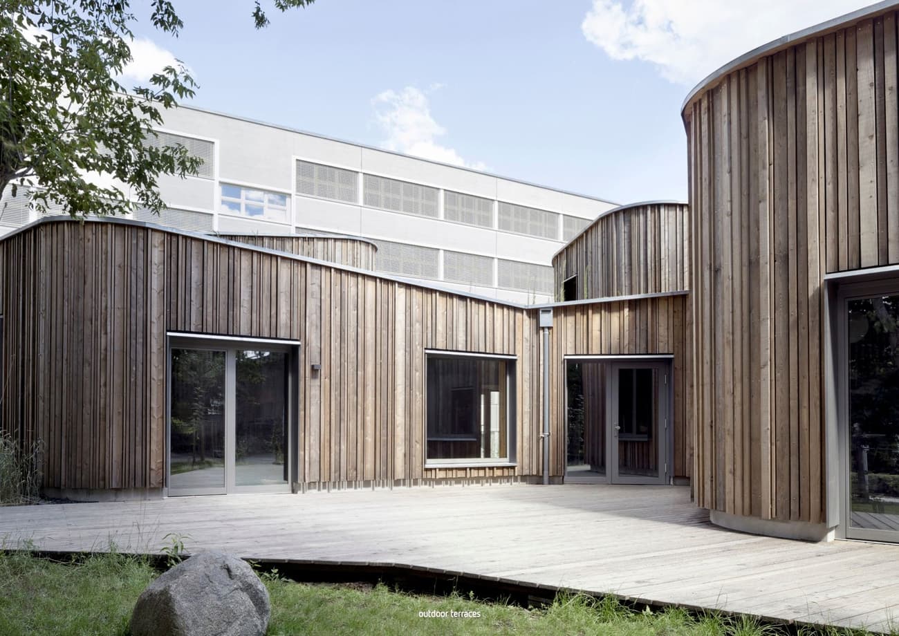 Architectural project - natural materials, wood, timber, raw materials, grey, outdoor space, passive design, sustainable design, warm tones, contemporary architecture, neutral tones, beige, wood facade, timber facade, exterior design, light wood, daylight optimization, Scandinavian influence, timber construction, honey wood, natural textures, minimalist design, tranquil setting, biophilic design, natural ventilation, timber cladding, wood cladding, modern architecture, textured wood, inviting space, garden view, eco-friendly building, green design, exterior wood, wooden deck, educational space, school building, light facade, public building, circular shapes, curved design, courtyard, timber decking, educational architecture, architectural rhythm