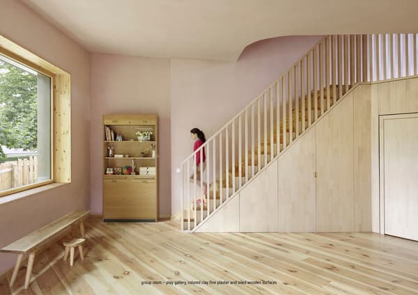 Architectural project - pastel pink, indoor space, natural materials, wooden bench, pink, wood, natural light, warm tones, neutral tones, beige, light wood, eco friendly, modern design, simple design, natural textures, Scandinavian style, eco materials, natural finish, cozy vibe, inviting home, large window, plaster, wooden interior, family space, warm atmosphere, bright interior, interior design, playful space, playroom, children's room, light wood flooring, wooden stairs, minimalist shelving, pastel walls, kid friendly, sustainable interior, residential area, wood frame window, plywood details, soft colors, residential use, relaxed space, wooden furniture