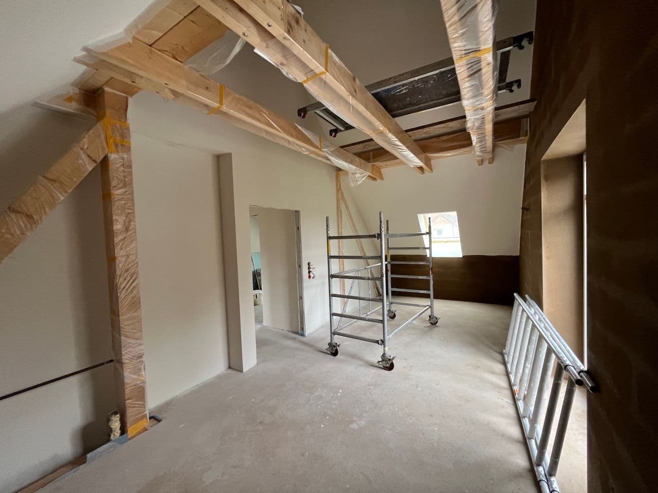 Architectural project - renovation project, renovation design, interior construction, residential project, renovation site, unfinished walls, new build, indoor space, sustainable materials, wood, timber, scaffolding, raw materials, natural light, eco design, neutral tones, construction phase, construction site, work in progress, exposed beams, ceiling beams, daylight, industrial vibe, construction materials, beige, brown, architectural elements, light wood, natural wood, wooden beams, timber beams, minimalist design, construction details, building process, white, plaster, airy space, modern home, plaster walls, open space, structural elements, warm palette, home renovation