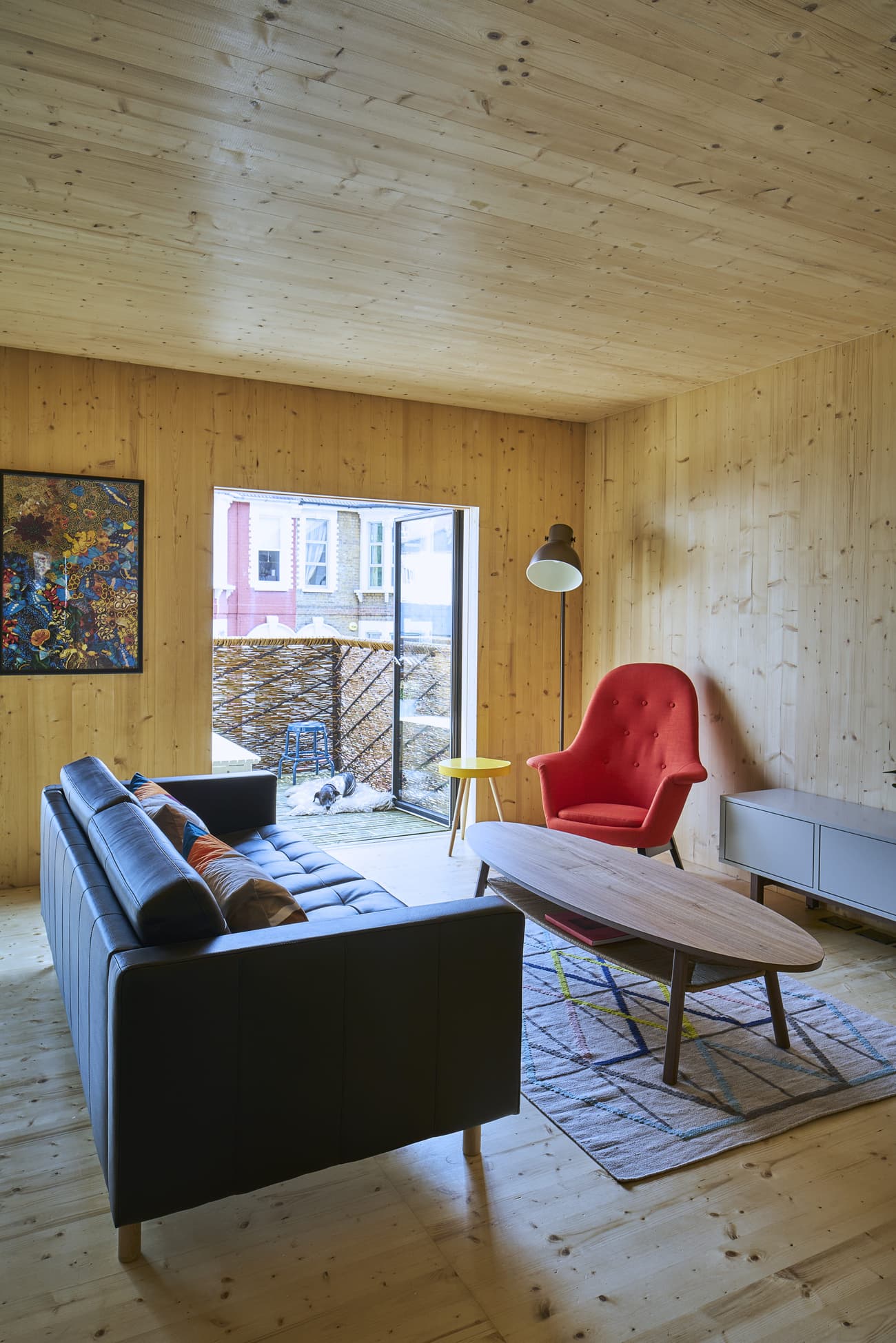 Architectural project - relaxation space, natural materials, wood, timber, natural light, sustainable design, yellow, glass, warm tones, neutral tones, daylight, timber ceiling, beige, light wood, natural wood, modern design, honey wood, Scandinavian style, timber floor, wooden floor, black, timber walls, clean lines, eco friendly home, cozy vibe, Nordic style, wood walls, timber interior, open layout, inviting space, minimalist decor, warm atmosphere, warm colors, modern living room, comfortable seating, glass door, lounge area, earthy textures, wood ceiling, family room, wooden furniture, indoor outdoor flow, simple furniture, cozy living room, floor lamp, wood interior, minimalist living room, bright room, cozy sofa, black sofa, red chair, bold accent, pop of color, geometric rug, colorful rug, artwork display, wall art, reading lamp, uncluttered space, red