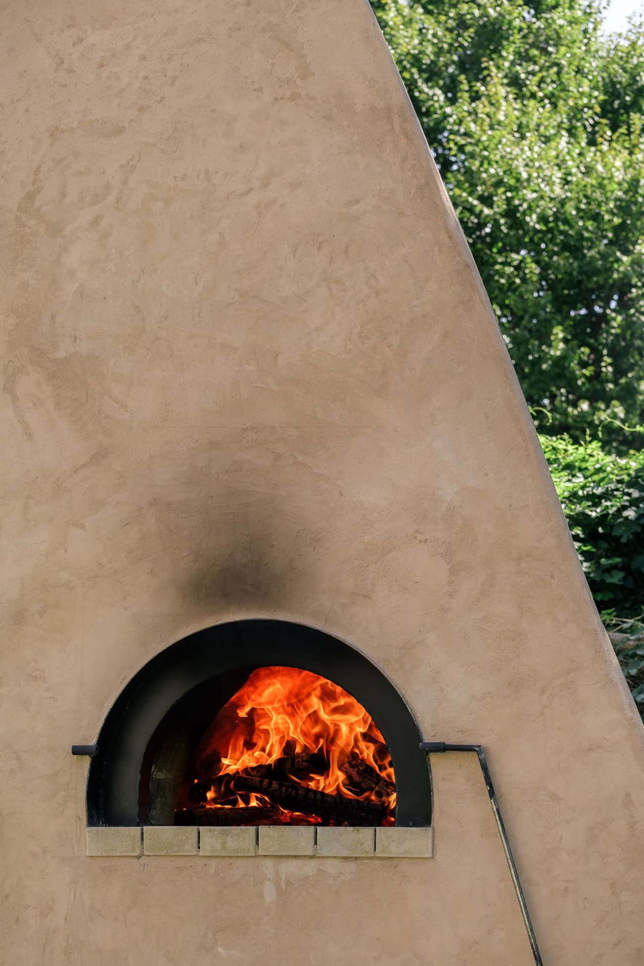 Architectural project - natural materials, sustainable design, warm tones, beige, eco friendly, natural setting, leisure space, low carbon, stone base, plaster, informal dining, inviting space, outdoor oven, pizza oven, wood-fired oven, outdoor cooking, clay oven, earthy tones, warm atmosphere, clay, outdoor fireplace, adobe oven, backyard feature, rustic oven, plaster finish, clay finish, traditional design, Mediterranean style, Tuscan vibe, cozy outdoor, al fresco dining, outdoor gathering, garden feature, brick arch, firewood, terracotta color, garden design, backyard zone, outdoor entertaining, warm climate, rustic ambiance, handcrafted look, artisanal feature, fire cooking, natural fire, passive heating, clay structure, outdoor craftsmanship, terracotta, brick