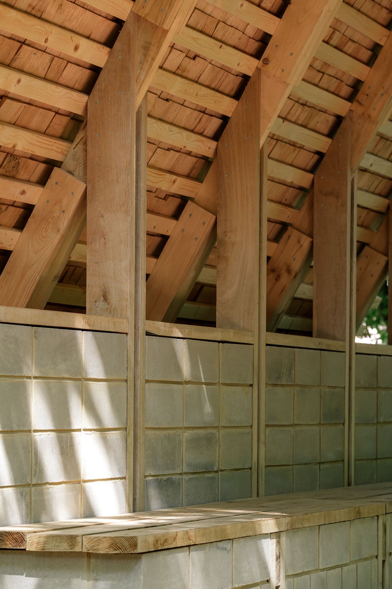 Architectural project - wood, timber, grey, wooden frame, natural light, sustainable design, warm tones, timber structure, exposed beams, beige, brown, natural wood, wooden beams, outdoor structure, rural architecture, simple design, natural textures, raw wood, earthy materials, stone, earthy tones, sloped roof, traditional architecture, wooden architecture, handcrafted, stone wall, rustic barn, wooden barn, countryside building, gable roof, eco-friendly building, cozy shelter, textured walls, grey stone, stone blocks, barn style, vernacular design, artisanal, wood grain, sunlit, warm light, country vibe, rural vibe