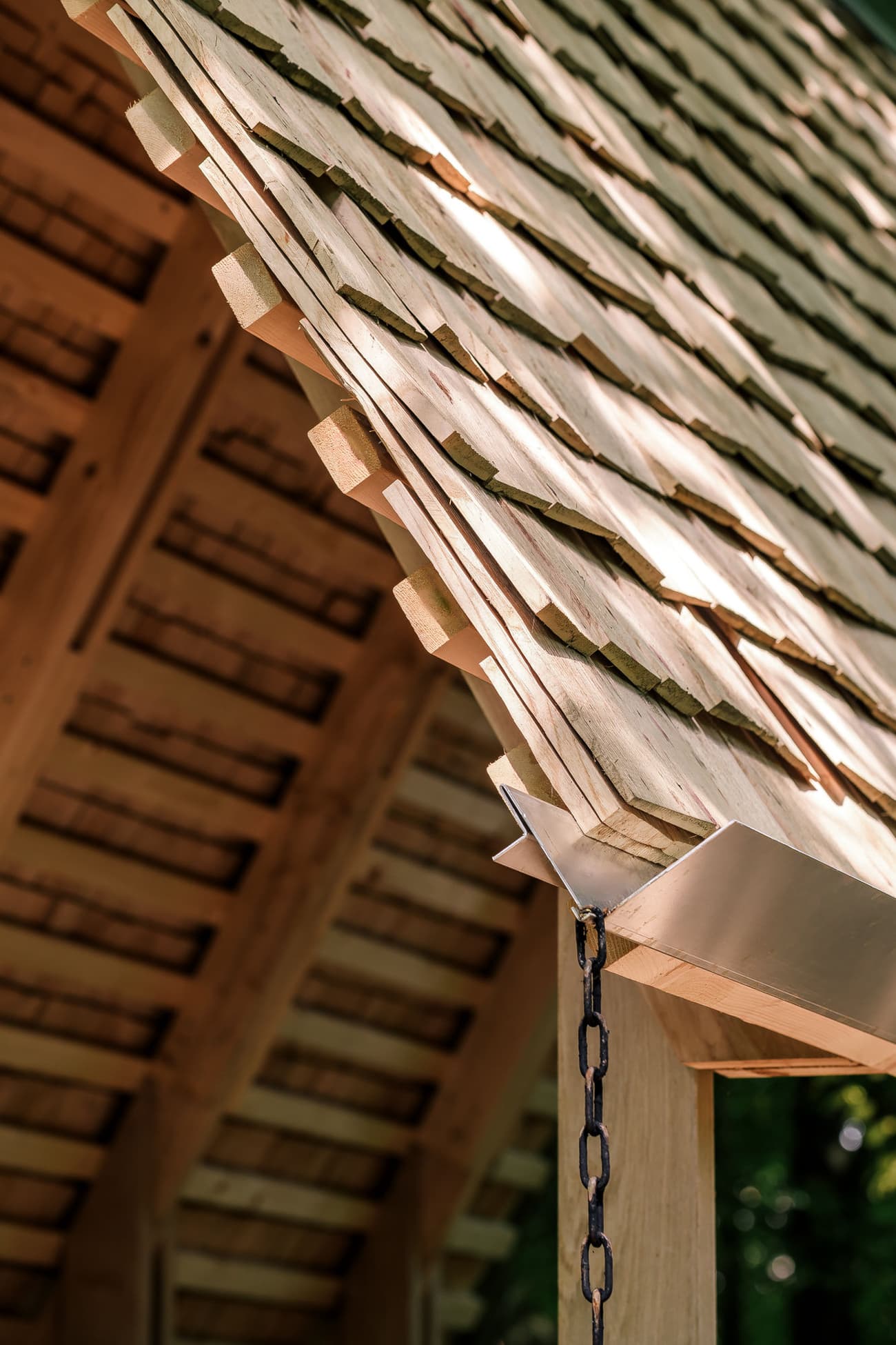 Architectural project - natural materials, architectural detail, sustainable materials, timber frame, timber structure, exposed beams, light wood, eco friendly, farmhouse style, outdoor structure, timber construction, simple design, honey wood, natural textures, rustic charm, timber detailing, construction detail, timber cladding, wood roof, wooden shingles, cedar shingles, sloped roof, pitched roof, rustic design, traditional architecture, exterior elements, wooden architecture, shelter design, canopy roof, shed roof, warm colors, nature-inspired, organic materials, handcrafted, rural style, countryside architecture, pavilion roof, artisanal craftsmanship, natural aesthetics