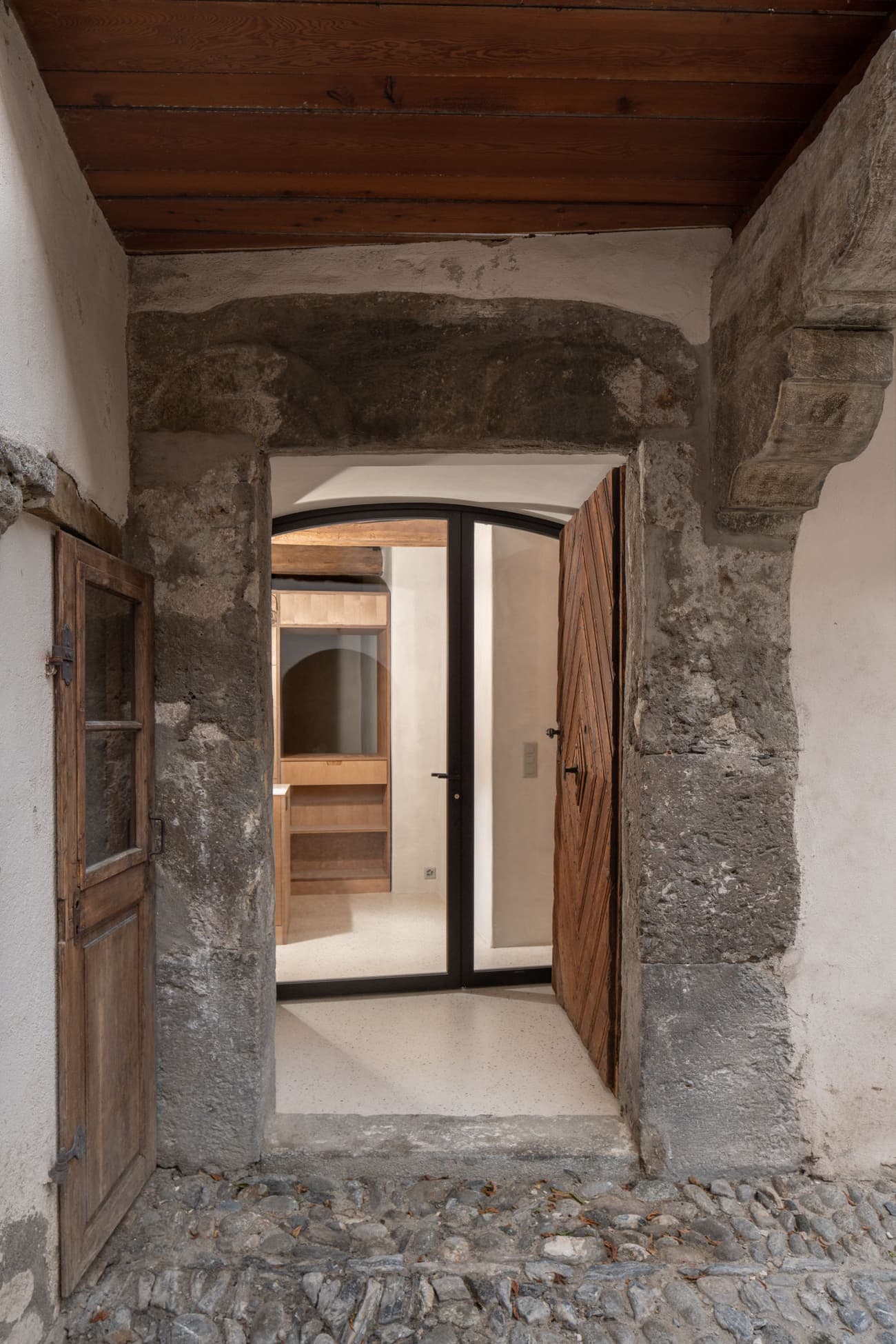Architectural project - stone masonry, textured stone, rustic stone, cozy ambiance, minimalist door, welcoming entrance, historic building, inviting entry, vintage feel, cobblestone path, European style, rustic entry, renovated entry, medieval touch, warm welcome, castle-like, stone materials, narrow entrance, intimate space, architectural detail, wood, wooden frame, natural tones, beige, brown, concrete, light wood, rural architecture, natural textures, rustic charm, neutral palette, warm wood, timber elements, earth tones, cozy vibe, stone, timber ceiling, traditional design, stone arch, heritage building, traditional style, textured walls, mixed materials, wooden door, entryway
