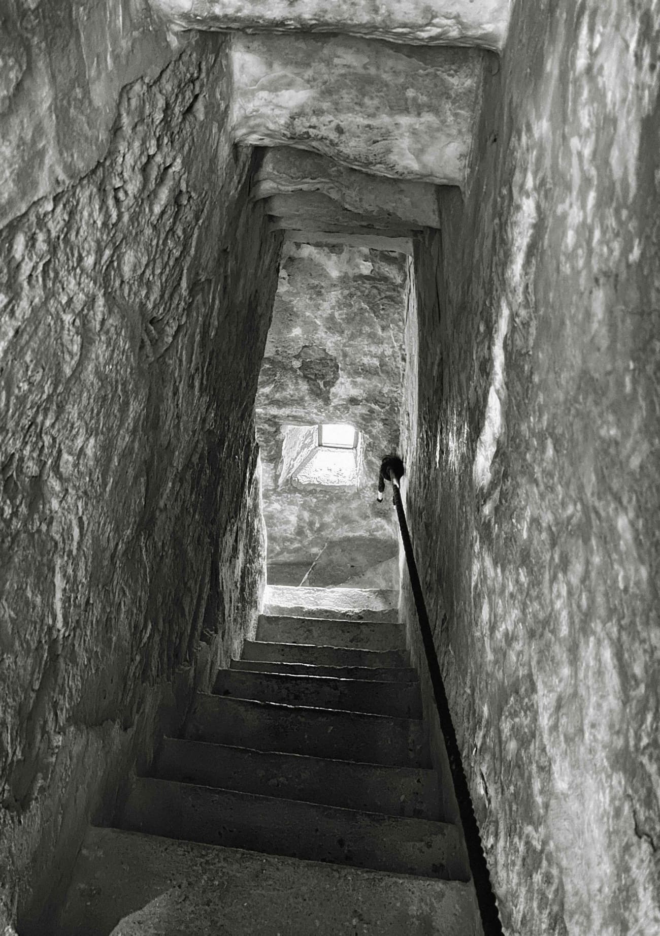 Architectural project - passageway, stone walls, old-world charm, architectural heritage, low light, enclosed space, rustic walls, narrow space, heritage site, aged stone, ancient vibe, rustic stairs, dark atmosphere, weathered stone, historical architecture, monochrome, historical site, stair railing, heritage restoration, grey, neutral tones, rustic charm, stone, rough texture, excavation site, timeless design, stone texture