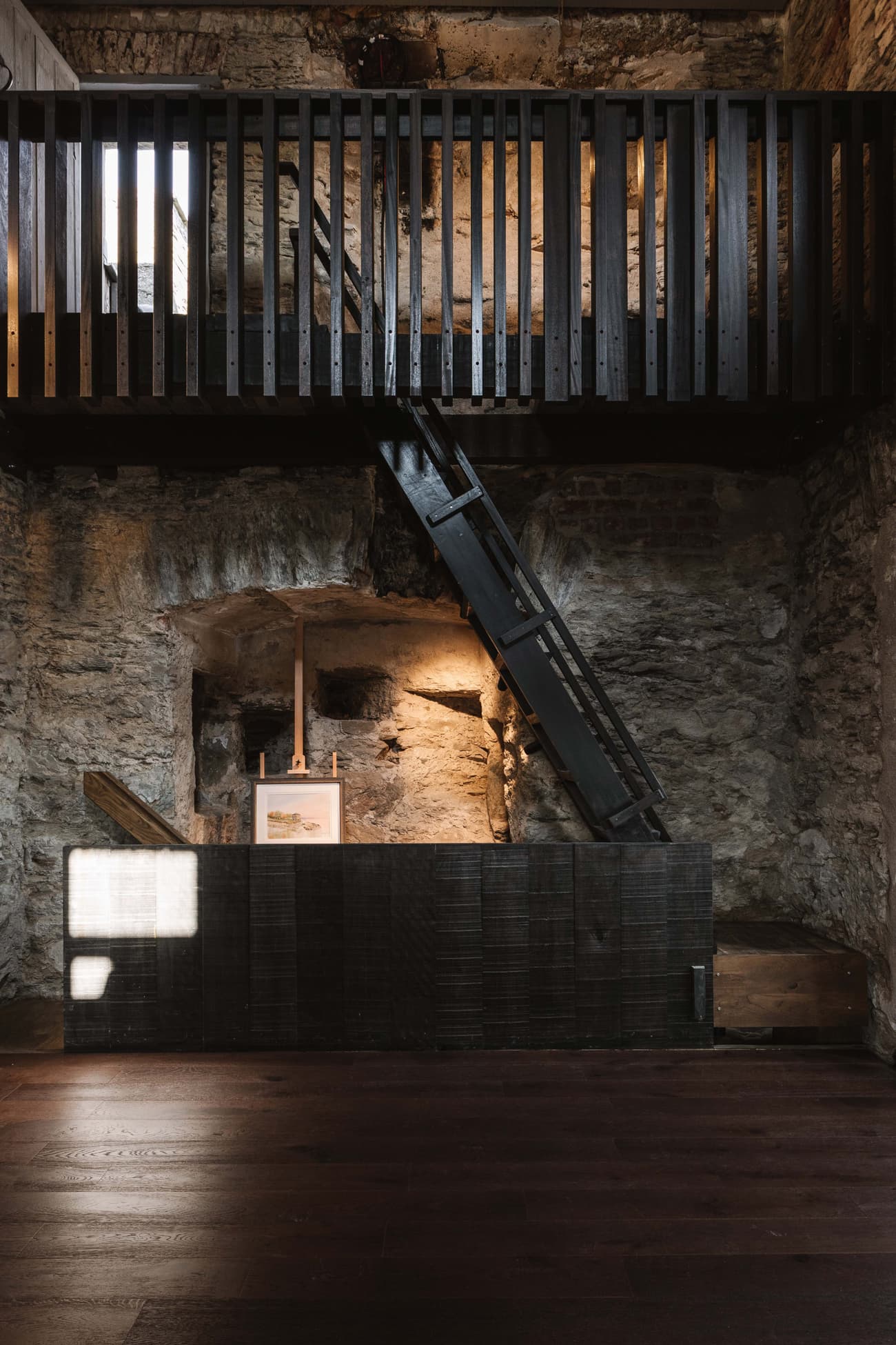 Architectural project - raw finishes, exposed materials, loft style, exposed stone, creative studio, modern renovation, artistic vibe, rugged texture, rustic interior, atmospheric, historic building, vintage charm, dramatic lighting, art display, intimate space, wood, timber, eclectic style, brown, contemporary touch, minimalist design, black, industrial chic, stone, textured wood, inviting space, earthy tones, stone wall, cozy atmosphere, heritage building, open space, minimal decor, timber railing, warm lighting, architectural contrast, dark wood, high ceiling, double height