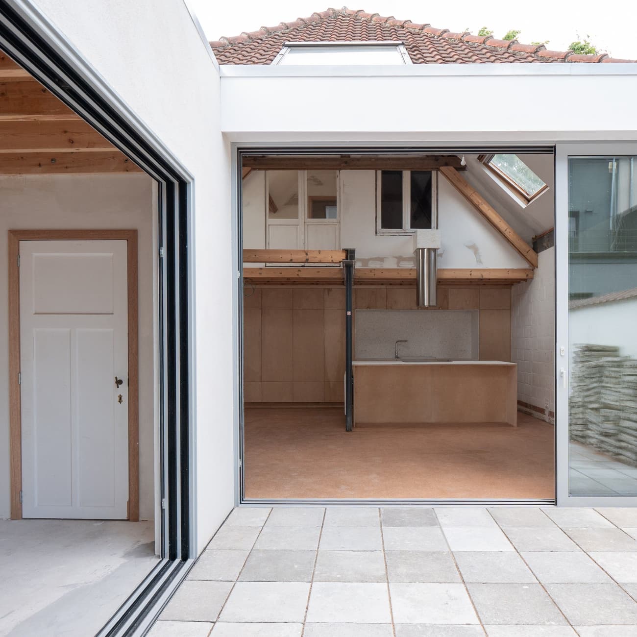 Architectural project - modern renovation, home extension, attic conversion, airy room, wood details, brick tiles, integrated kitchen, wood, timber, natural light, sustainable design, glass, warm tones, grey, neutral tones, exposed beams, beige, concrete, light wood, daylight optimization, compact space, wood beams, neutral palette, minimalist design, glass doors, multifunctional, Scandinavian vibe, timber elements, passive house, contemporary home, white walls, indoor outdoor, white, Nordic style, energy efficient, cozy kitchen, open layout, open plan, terracotta, bright space, sliding doors, residential, home, eco renovation, terracotta floor, skylight, urban living