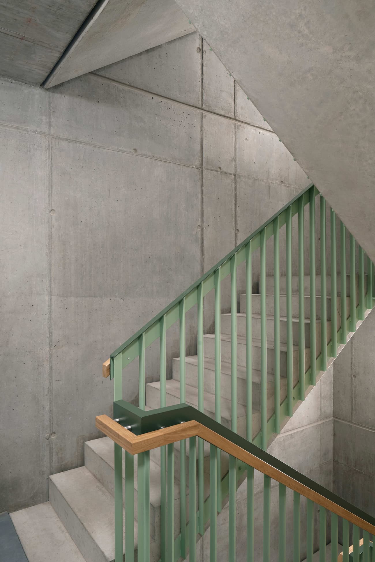 Architectural project - metal railing, concrete finish, exposed concrete, modern industrial, loft style, raw aesthetic, unfinished look, urban chic, polished concrete, concrete walls, textured concrete, concrete stair, green accent, contemporary look, architectural detail, eco-friendly design, wood, raw materials, grey tones, metal, grey, green, urban environment, industrial vibe, concrete, structural design, light wood, industrial elements, architectural texture, minimalist vibe, minimalist architecture, neutral palette, minimalist design, urban space, industrial chic, durable materials, modern architecture, sleek design, simple lines, urban style, green railing, urban interior