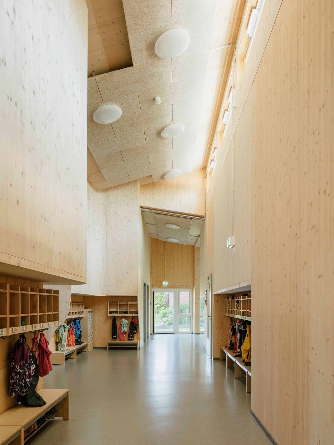 Architectural project - exposed timber, open ceiling, bright hallway, indoor space, wood, timber, natural light, sustainable design, warm tones, neutral tones, daylight, gathering space, beige, light wood, natural wood, functional design, eco friendly, modern design, honey wood, contemporary design, Scandinavian style, minimalist design, community center, timber walls, low carbon, passive house, clean lines, Nordic style, timber ceiling, inviting space, wood texture, educational space, educational building, public building, hallway, modern interior, organized space, skylight, high ceiling, double height, wood interior