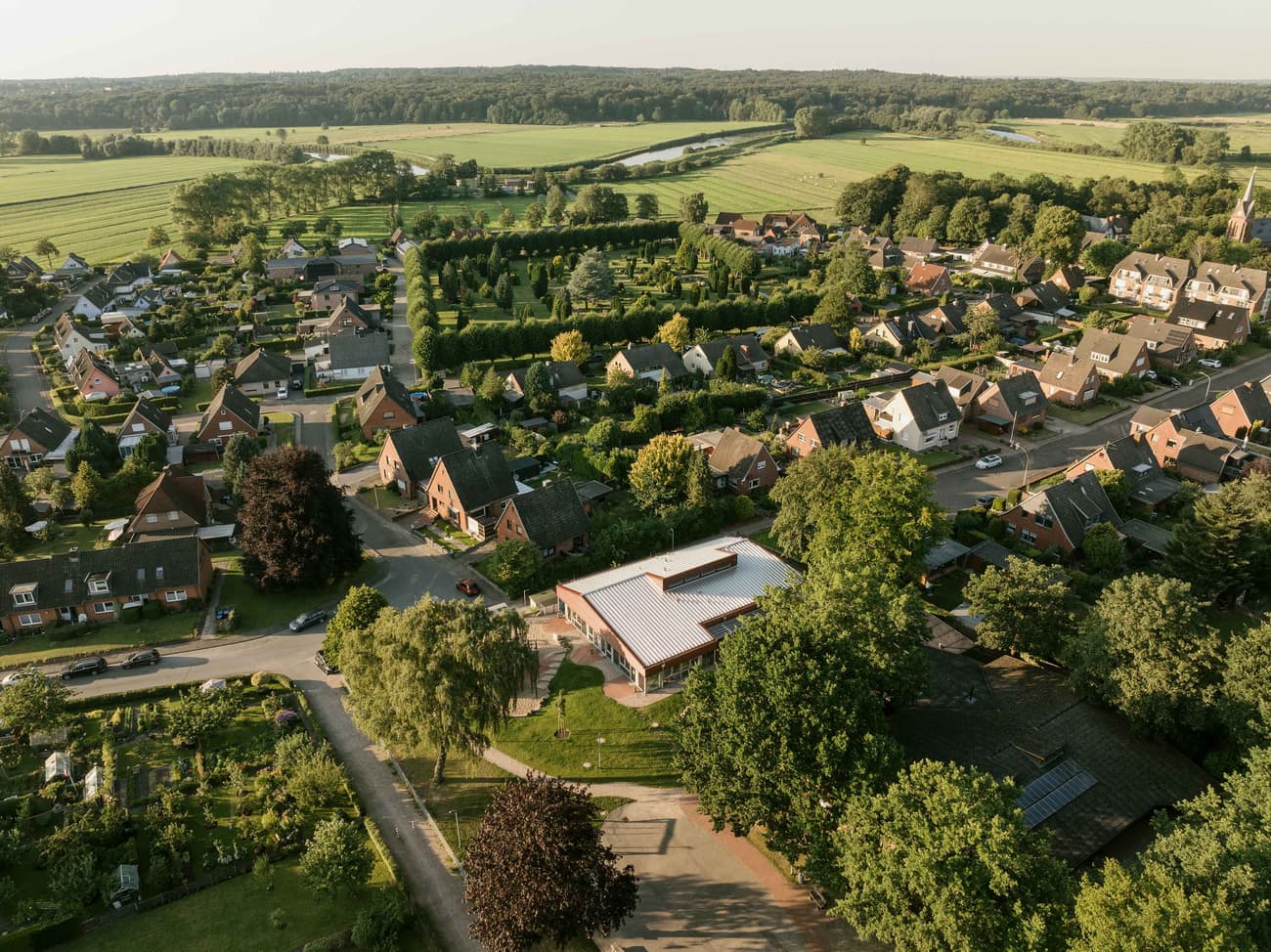Architectural project - peaceful environment, rural landscape, external view, pastoral setting, green fields, aerial shot, suburban homes, outdoor living, passive design, eco design, landscape architecture, natural setting, rural design, panoramic view, environmental design, rustic ambiance, countryside, greenery, tranquil atmosphere, nature integration, lush greenery, green surroundings, open space, residential area, trees, sustainable living, nature harmony