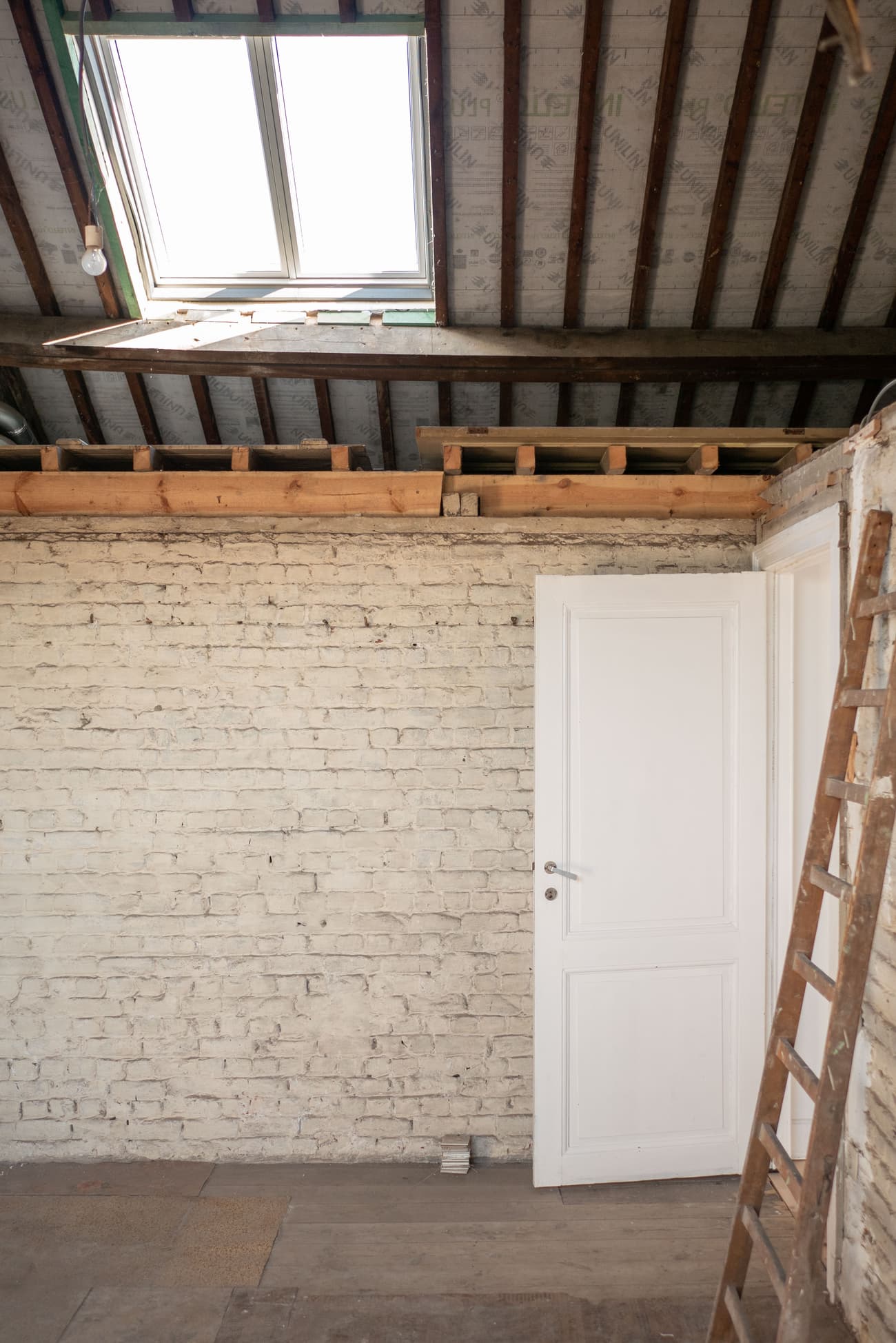 Architectural project - brick wall, unfinished wall, attic space, loft conversion, white door, renovation project, rustic elements, wood, timber, raw materials, natural light, warm tones, neutral tones, work in progress, under construction, exposed beams, daylight, beige, multifunctional space, wooden beams, simple design, rustic vibe, timber beams, rustic modern, industrial touch, minimalist style, timber floor, wood floor, white, cozy vibe, architectural details, brick, bright space, open space, eco renovation, sustainable renovation, skylight, home renovation