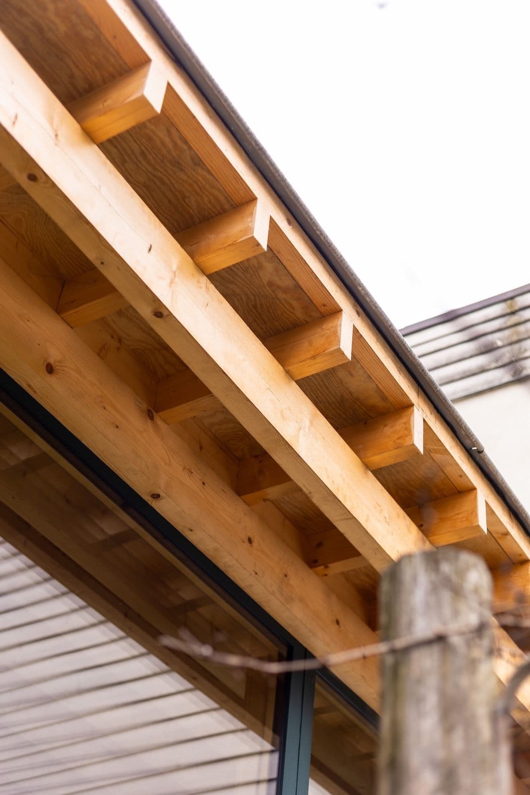 Architectural project - daylight design, minimalist detail, house detail, timber eaves, wood eaves, overhang, wooden home, timber home, beam alignment, natural materials, architectural detail, wood, timber, natural light, passive design, warm tones, eco design, contemporary architecture, sustainable architecture, exposed beams, beige, wood facade, roof detail, light wood, low carbon design, eco friendly, exterior detail, timber construction, simple design, honey wood, wood beams, timber beams, wood construction, natural finish, sustainable building, structural detail, modern rustic, clean lines, timber cladding, wood cladding, Nordic style, beige tones, natural texture, rustic architecture, residential architecture, outdoor architecture, cozy exterior, wooden facade, Scandinavian design, inviting facade