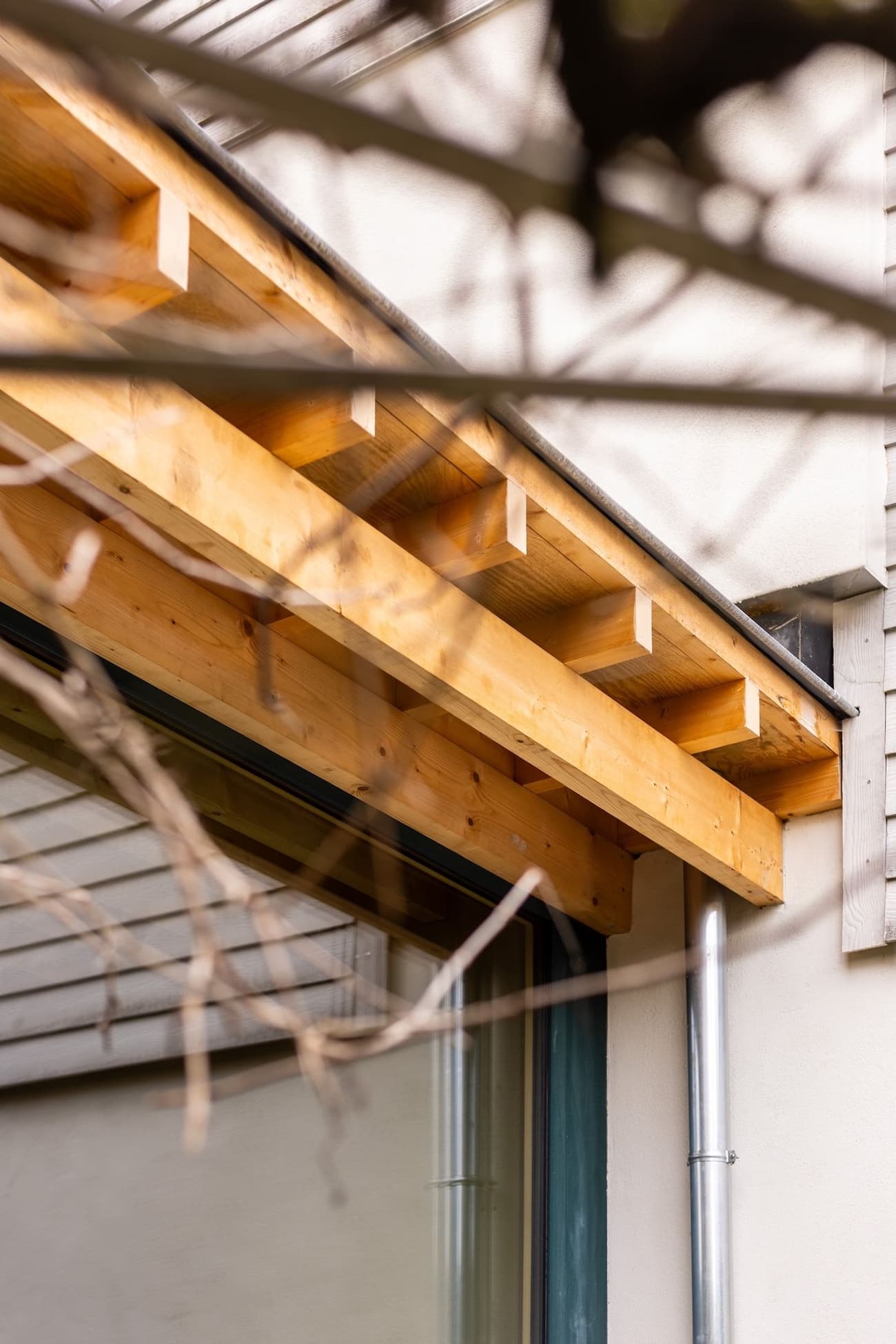 Architectural project - pergola, timber beam, exterior finish, outdoor detail, eaves, wooden eave, timber eave, building exterior, minimal design, architectural detail, sustainable design, warm tones, contemporary architecture, exposed beams, timber facade, architectural elements, timber detail, exterior design, light wood, natural wood, eco friendly, modern design, timber construction, simple design, honey wood, facade detail, natural textures, eco materials, wood construction, light tones, warm wood, structural detail, construction detail, timber cladding, wood cladding, modern architecture, residential architecture, sustainable material, natural construction, wooden facade, wooden structure, earthy textures, home renovation