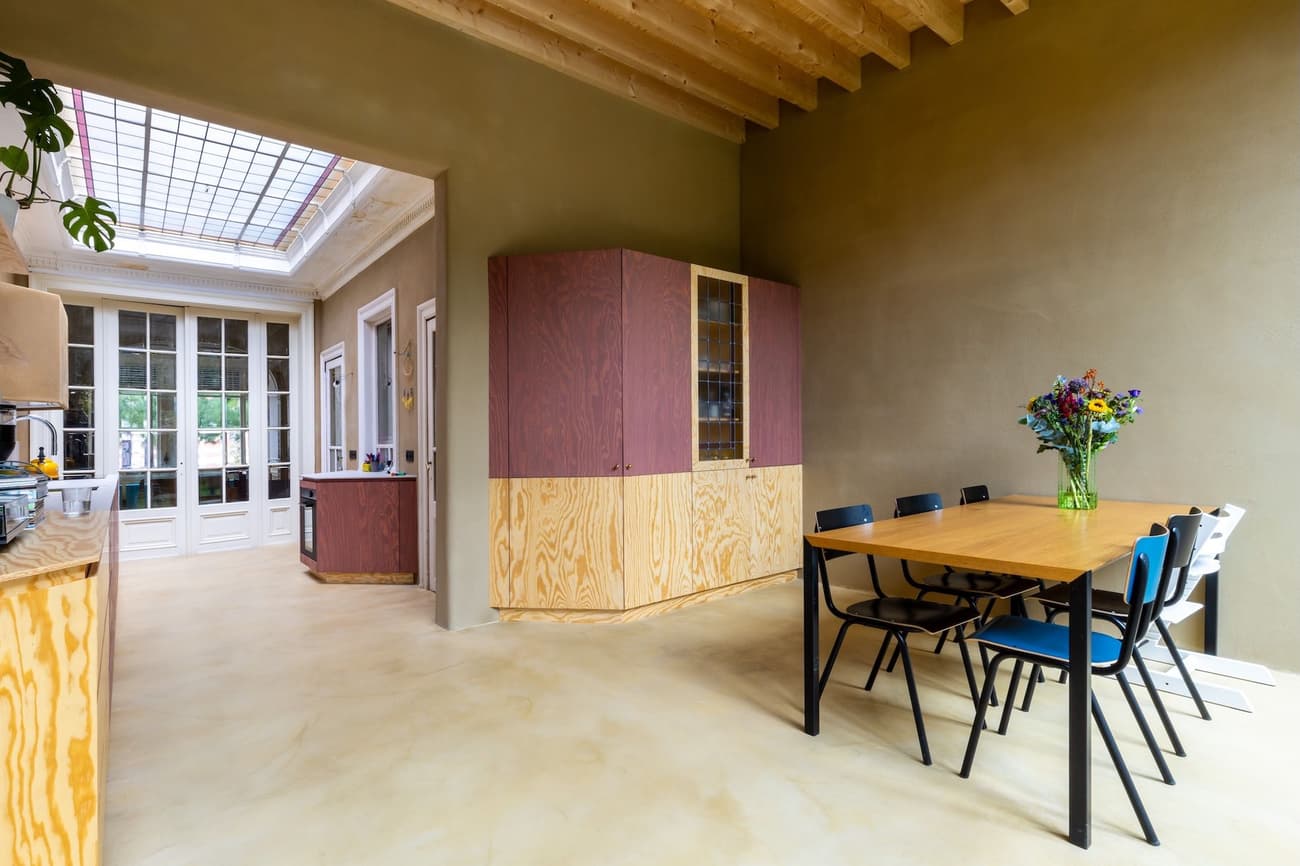 Architectural project - playful interior, dining room, wood furniture, vibrant accents, homey vibe, light wood floor, wooden cabinet, colorful chairs, minimalist table, timber furniture, eclectic seating, simple dining, unique cabinetry, French doors, greenery inside, multicolored chairs, bright decor, rustic flair, purple, indoor space, wood, timber, natural light, sustainable design, glass, neutral tones, exposed beams, daylight, beige, light wood, blue, contemporary touch, natural textures, timber floor, casual gathering, glass doors, modern rustic, eco friendly home, plaster, timber ceiling, warm ambiance, informal dining, open layout, open plan, dining area, inviting space, earthy tones, casual dining, cozy atmosphere, seamless transition, wood ceiling, pastel walls, pendant lamp, home renovation, indoor plants, welcoming home, family-friendly