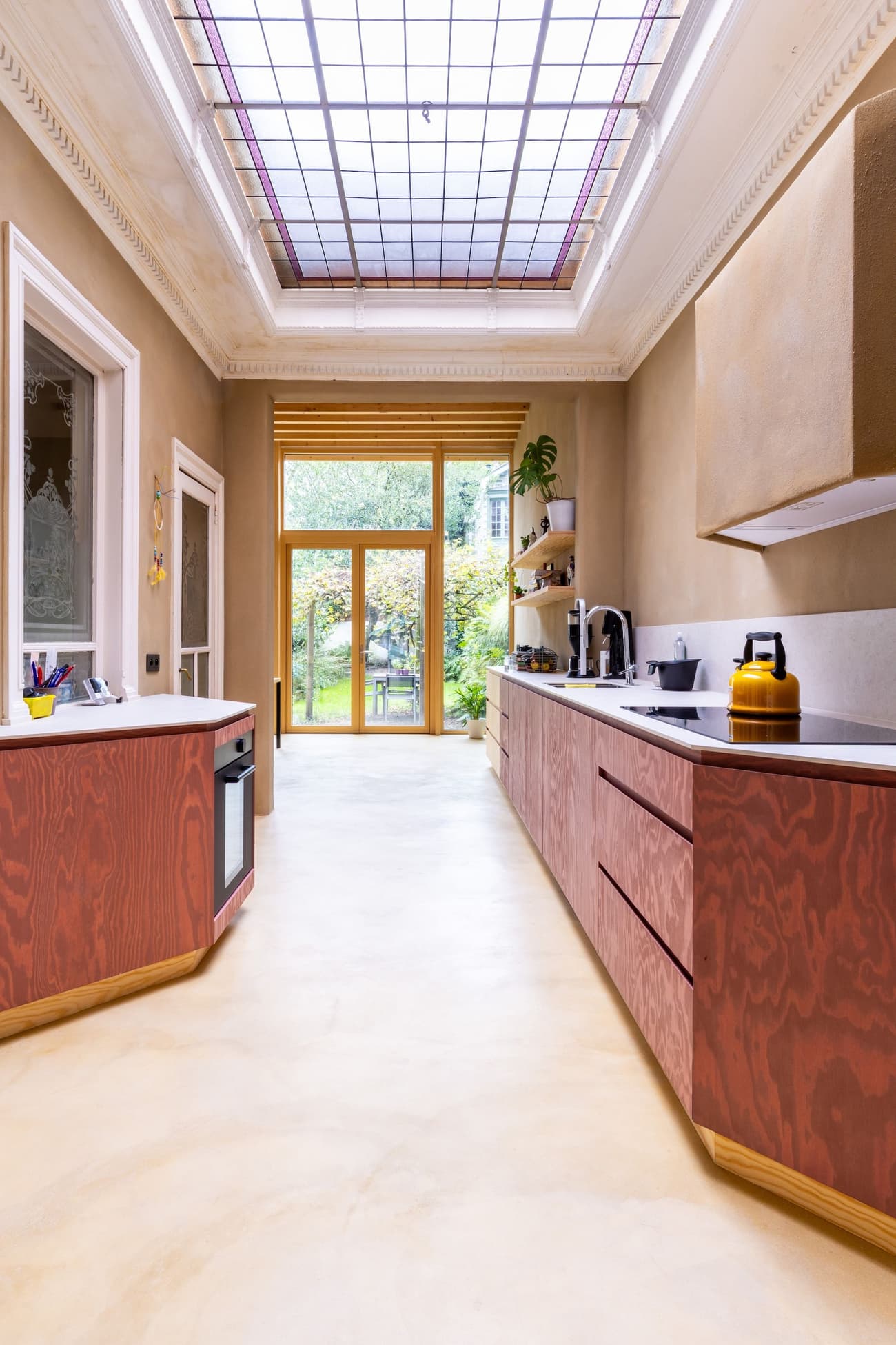 Architectural project - sustainable, beige floor, terrazzo style, cooking space, stylish kitchen, stained glass, elegant interior, wooden cabinets, glass ceiling, pink wood, pastel wood, warm floor, terrazzo floor, brass accents, brass details, minimalist, wood, natural light, warm tones, eco design, neutral tones, functional space, beige, brown, daylight optimization, eco friendly, modern design, contemporary design, Scandinavian style, multifunctional, low carbon, indoor outdoor, plaster, cozy kitchen, family kitchen, home kitchen, bright kitchen, open layout, open plan, inviting space, Nordic vibe, garden view, textured walls, modern kitchen, sleek design, compact kitchen, interior, efficient layout, plaster walls, minimal decor, smooth surfaces, modern interior, seamless design, kitchen, skylight