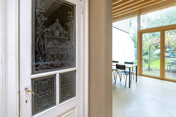 Architectural project - beige walls, airy interior, dining room, peaceful home, modern extension, cozy room, home addition, natural materials, wood, timber, raw materials, natural light, sustainable design, glass, warm tones, eco design, green building, contemporary style, neutral tones, exposed beams, daylight, beige, concrete, light wood, honey wood, glass doors, low carbon, sustainable home, indoor outdoor, elegant design, white, eco friendly home, Nordic style, plaster wall, plaster, timber ceiling, open layout, open plan, dining area, inviting space, minimalist decor, wooden flooring, garden view, Scandinavian design, sliding doors, seamless transition, comfortable living, wood ceiling, indoor outdoor flow, bright room