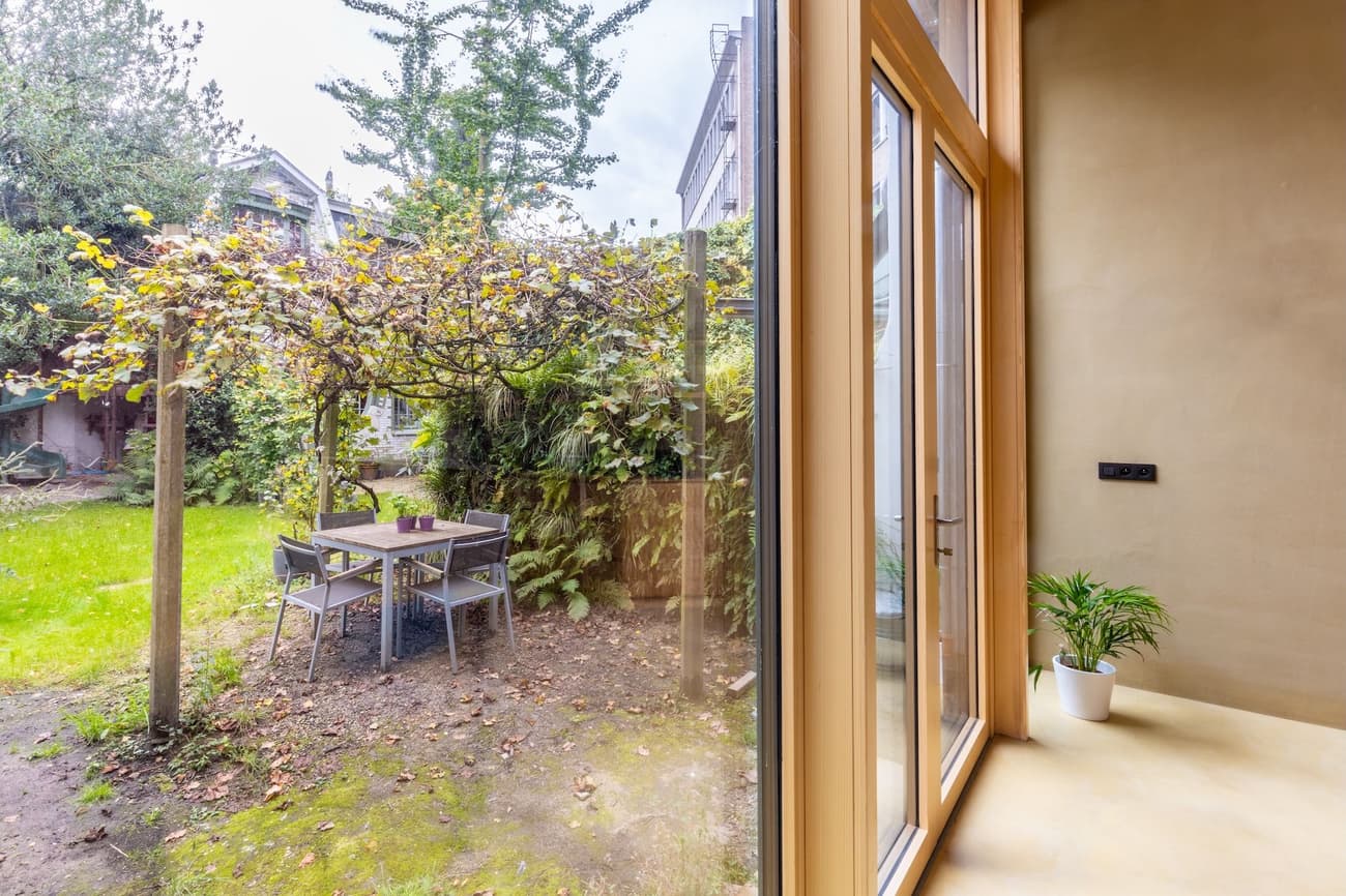 Architectural project - terrace, city garden, minimalist garden, potted plant, modern extension, small garden, patio doors, home addition, natural light, outdoor living, warm tones, eco design, outdoor area, functional space, daylight, compact space, natural setting, natural textures, relaxation spot, biophilic design, indoor outdoor, inviting home, open plan, earthy tones, garden dining, casual dining, nature connection, garden retreat, cozy corner, exterior view, garden view, calm atmosphere, wooden frames, fresh air, seamless transition, modern style, green space, urban garden, sustainable living, glass wall, simple furniture, backyard seating, light beige