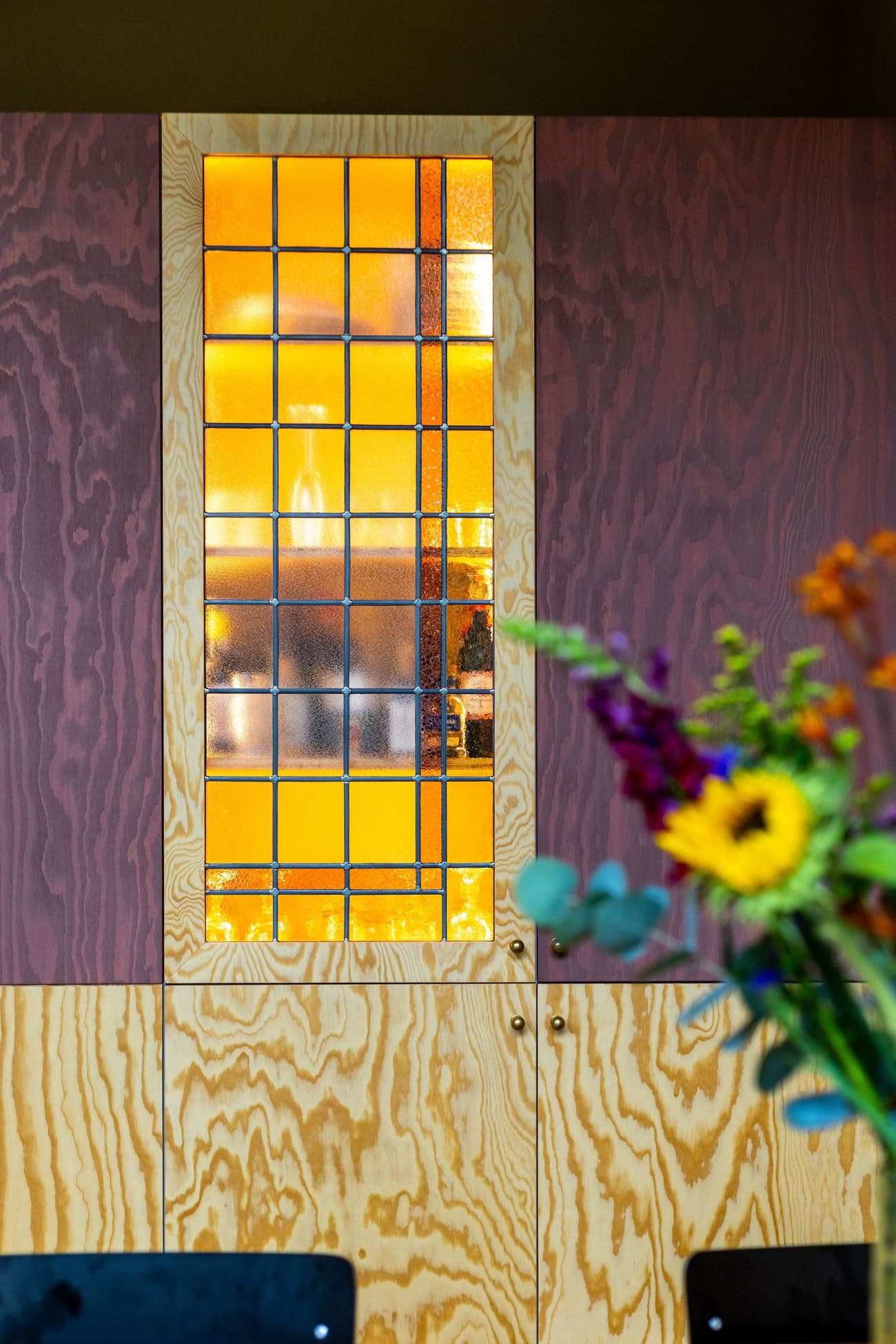 Architectural project - home decor, accent wall, creative design, Scandinavian touch, interior detail, visual contrast, stained glass, decorative glass, artistic panel, vibrant wood, artistic detail, colorful cabinet, orange glass, art deco style, Nordic aesthetic, floral arrangement, vibrant flowers, tall cabinet, wooden surface, stained glass window, natural pattern, bright color, unique finish, aesthetic blend, artful touch, rich tones, cozy interior, playful design, warm tones, contemporary style, natural wood, rustic modern, plywood wall, modern rustic, wood texture, warm ambiance, textured wood, cozy home, wood panel, home renovation, mixed materials, timber finish