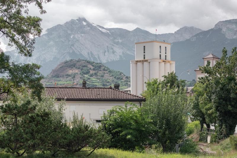 Architectural project - rural landscape, eco-friendly area, cloudy sky, roof tiles, calm surroundings, outdoor environment, historic building, peaceful view, mountain backdrop, vegetated area, local vegetation, outdoor landscape, village scene, picturesque view, idyllic setting, rural homes, nature surrounds, quiet living, scenic retreat, scenic mountains, community area, village life, neighborhood setting, forested area, picturesque landscape, outdoor space, rural architecture, rustic vibe, rustic charm, traditional building, serene atmosphere, scenic view, tranquil vibe, greenery, natural environment, nature escape, countryside living, peaceful living, lush greenery, greenery view, residential area, sustainable living, nature setting, natural beauty