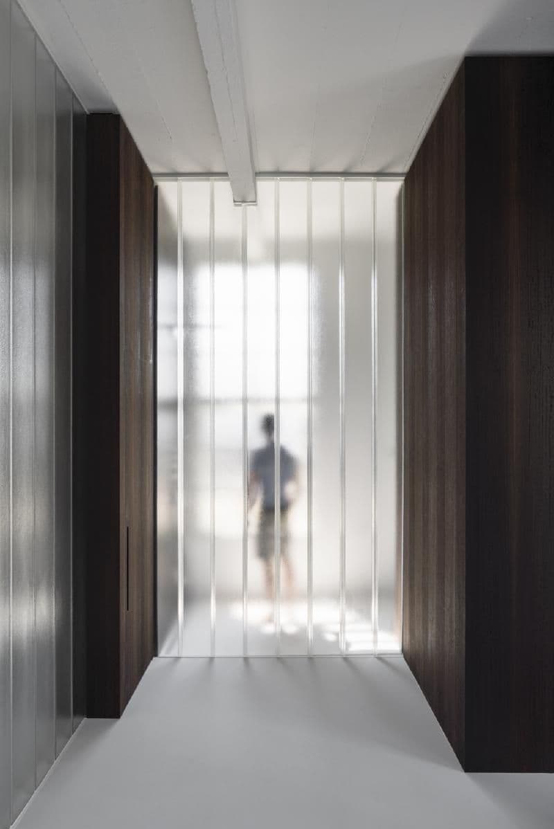 Architectural project - refined style, urban chic, subtle elegance, minimalist hall, streamlined design, modern corridor, white floor, glass corridor, glass hallway, brown wood walls, sharp geometry, visual depth, spatial contrast, sophisticated space, harmonious space, architectural refinement, light play, eco-friendly design, sustainable materials, natural light, warm tones, neutral tones, translucent panels, industrial vibe, brown, visual rhythm, contemporary design, industrial touch, neutral palette, clean lines, light filled, timber cladding, white, sleek design, bright space, calm atmosphere, soft light, vertical panels, modern interior, architectural feature, airy, frosted glass
