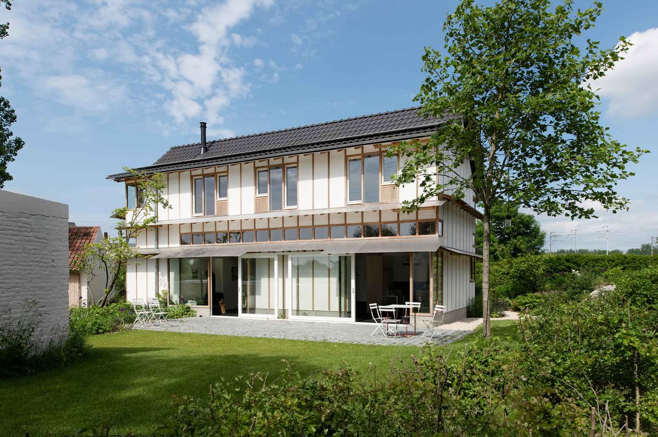 Architectural project - minimal design, relaxation space, sustainable materials, wood, timber, outdoor space, natural light, passive design, glass, contemporary style, green, daylight optimization, eco friendly, Scandinavian style, exterior, outdoor seating, glass doors, light tones, biophilic design, eco home, sustainable home, natural ventilation, modern facade, clean lines, white facade, large windows, simple elegance, white, Nordic design, inviting home, wood frame, energy efficient, airy space, green home, greenery, natural environment, garden view, residential architecture, nature integration, timber siding, family living, wood siding, timber framing, sliding doors, comfortable living, family house, private garden, green lawn, foliage, modern style, soft tones, seamless indoor outdoor, open view, patio furniture, modern living, spacious living, outdoor dining