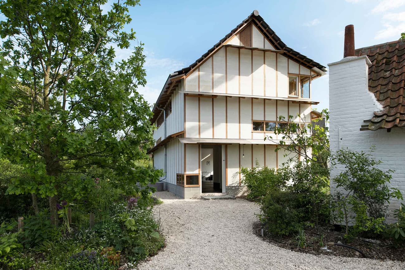 Architectural project - natural materials, wood, timber, raw materials, outdoor space, relaxed vibe, warm tones, green building, exposed structure, green, brown, timber facade, exterior design, eco friendly, Scandinavian influence, airy design, rustic modern, minimalist architecture, timber elements, circular design, modern rustic, eco home, passive house, natural ventilation, contemporary home, landscape integration, white walls, timber cladding, wood cladding, white, Nordic style, countryside home, energy efficient, sloped roof, pitched roof, nature-inspired, rural setting, garden view, gravel path, sustainable house, inviting exterior, modern living, white exterior, urban nature, residential, home, cozy vibes, front garden, textured roof, warm design, gravel