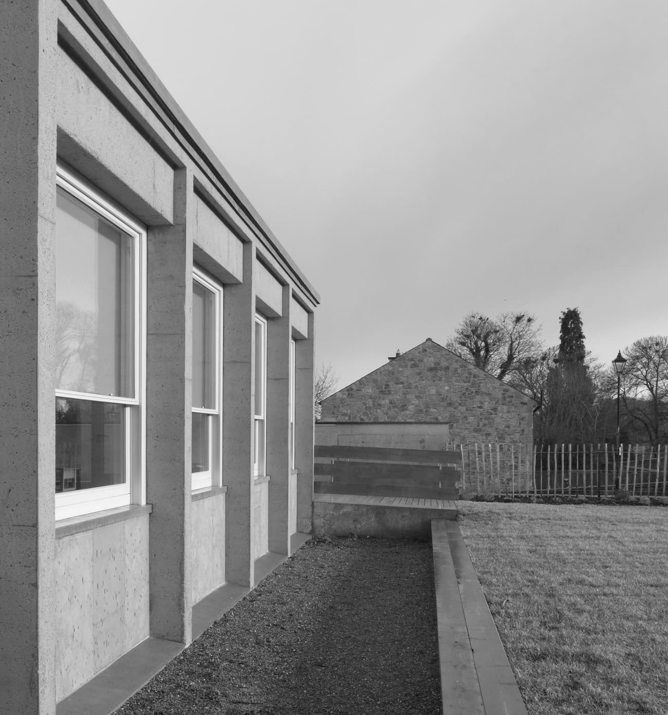 Architectural project - rural landscape, modern farmhouse, symmetrical design, natural materials, eco-friendly design, outdoor space, natural light, contemporary architecture, sustainable architecture, grey, neutral tones, daylight, concrete, sleek lines, minimalist style, minimalist design, outdoor seating, natural landscape, eco build, low carbon, thermal mass, large windows, architectural details, energy efficient, rough texture, countryside view, earthy tones, rural setting, garden view, nature integration, textured facade, passive solar, simple lines, modern exterior, insulation, suburban home, window frame, concrete wall, understated elegance, rural house, black and white